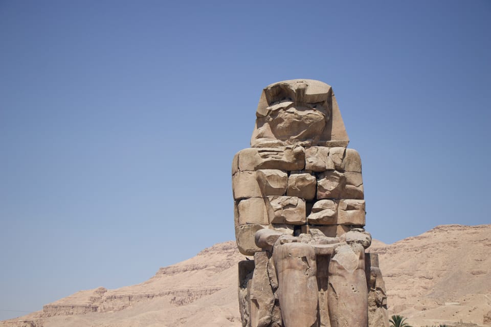 A crumbling Egyptian statue in the desert.